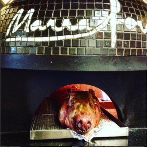 Roasted Pig cooking in a black tiled Marra Forni Brick Oven