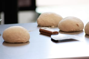 Dough Balls resting on a table next to dough cutter